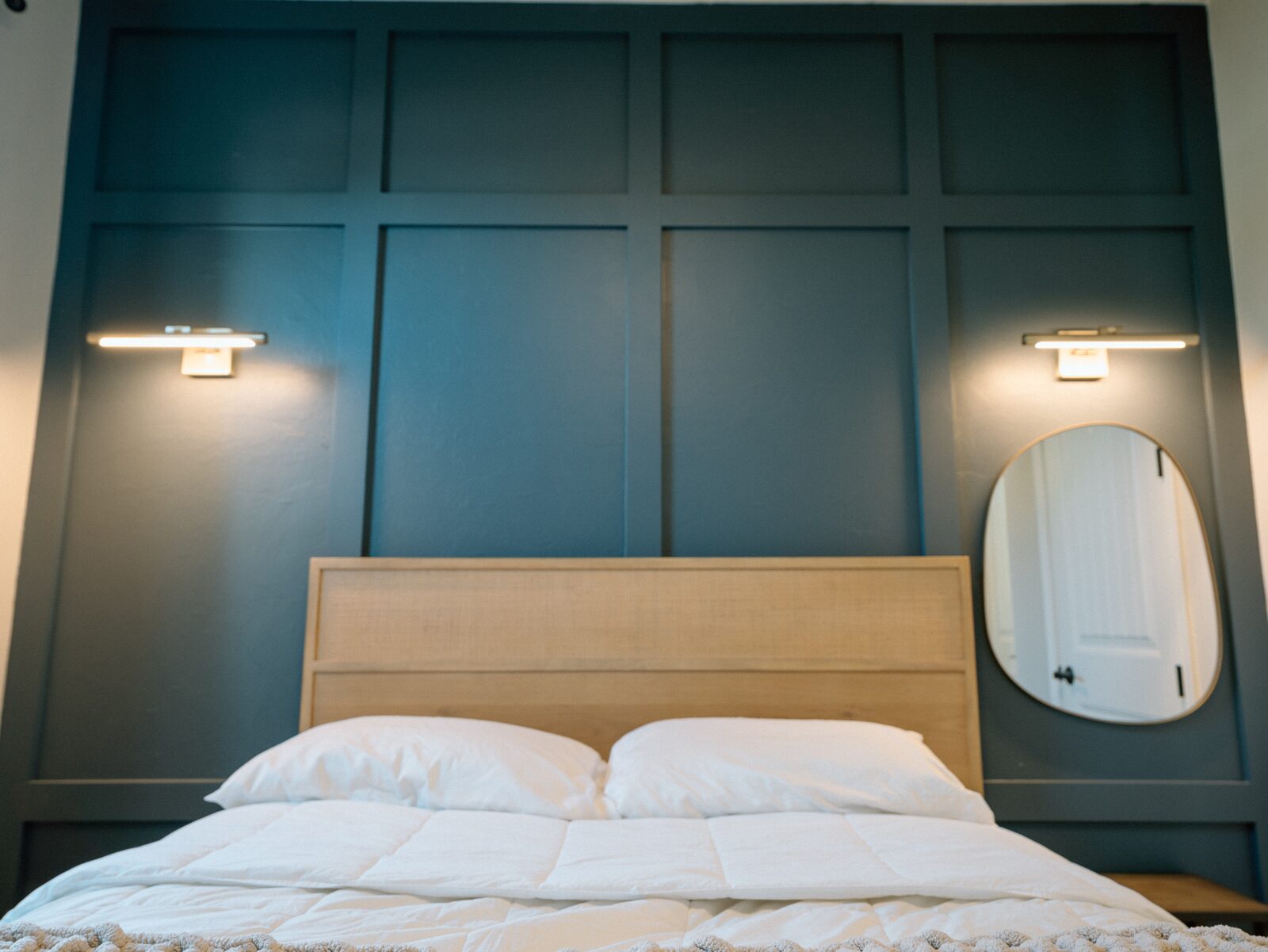 Board-and-batten bedroom accent wall with modern sconce lighting in Lakewood Ranch home