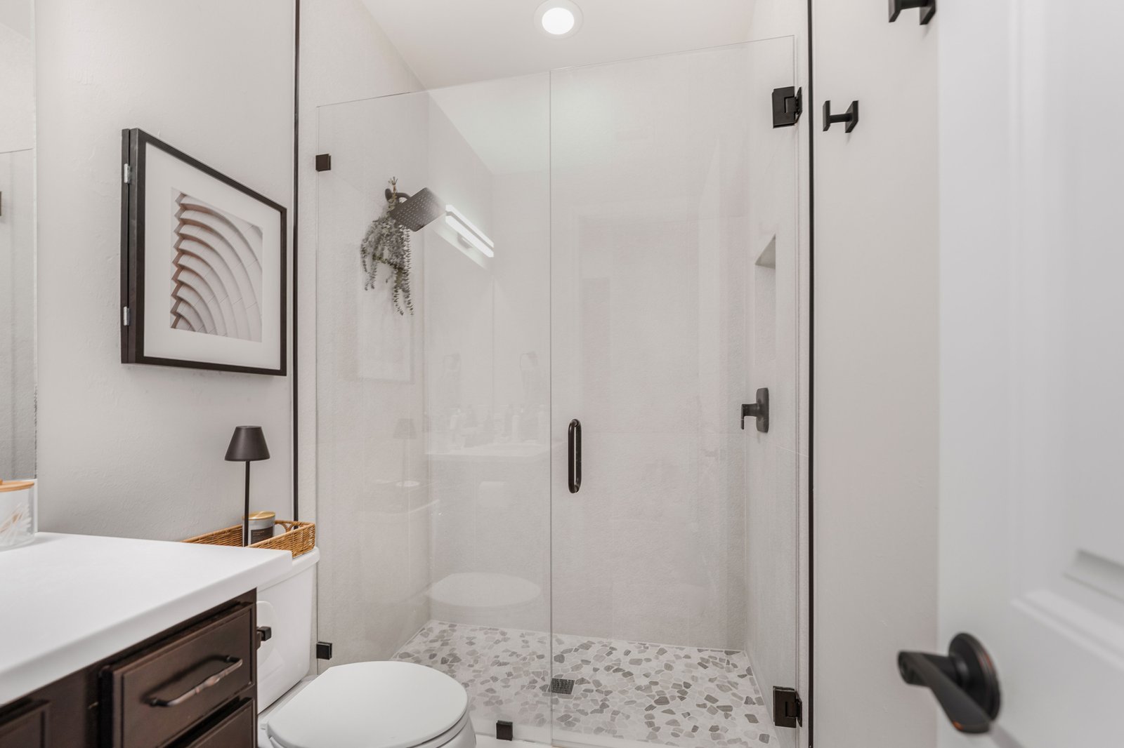 Modern bathroom renovation with frameless glass walk-in shower and pebble stone floor in Lakewood Ranch