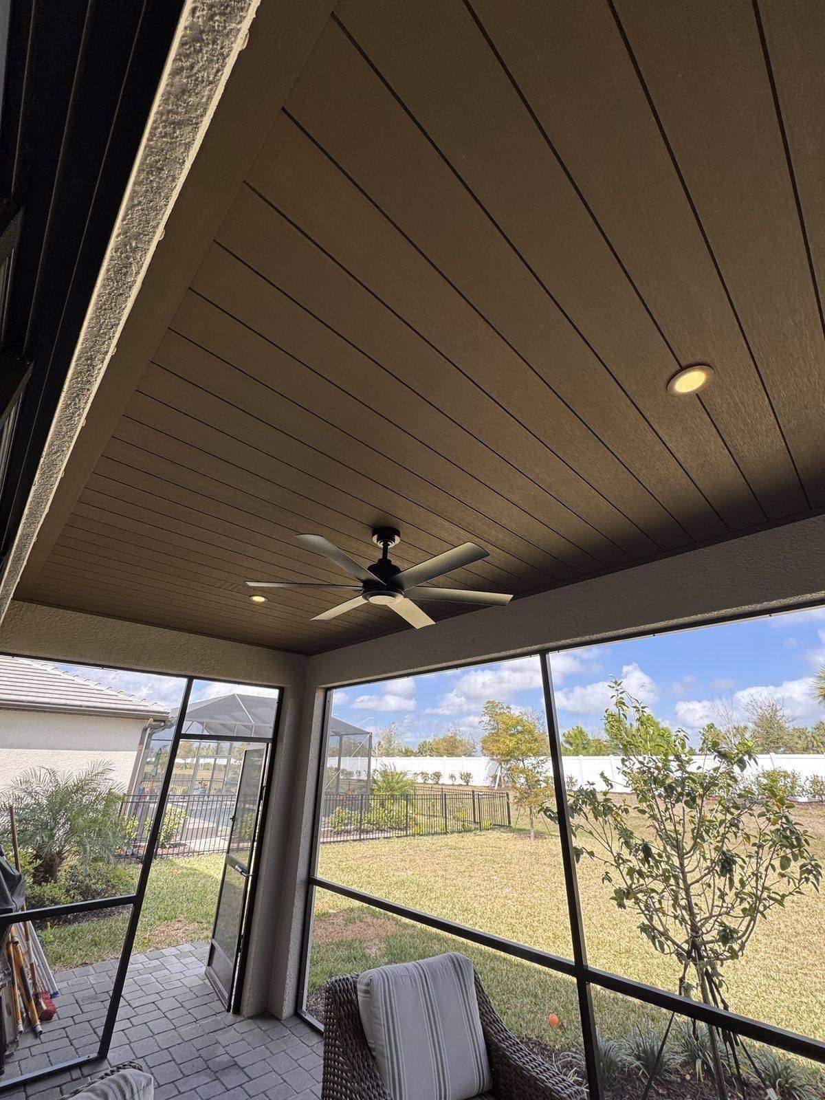 Screened lanai with tongue-and-groove ceiling, ceiling fan, and outdoor living space in Lakewood Ranch